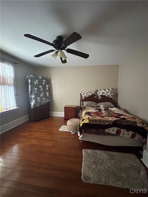 bedroom with baseboards, wood finished floors, and a ceiling fan