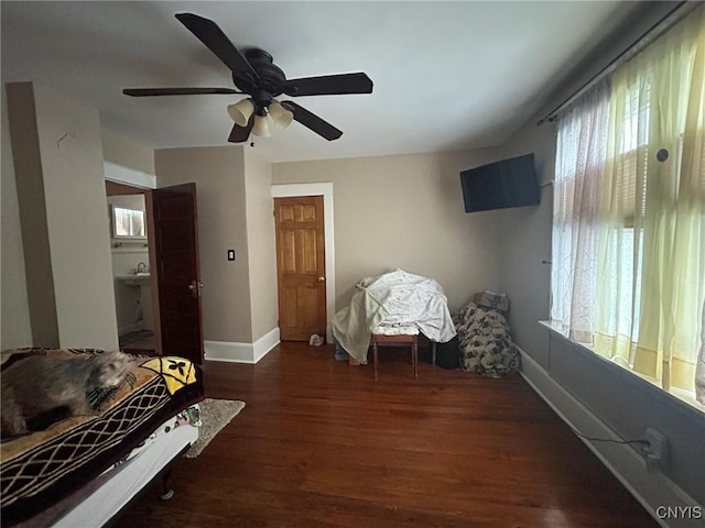 bedroom with ceiling fan, baseboards, and wood finished floors