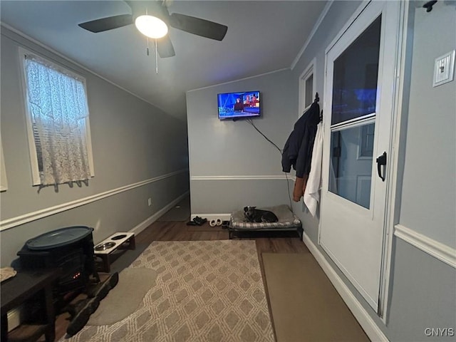 interior space with ceiling fan, lofted ceiling, baseboards, and wood finished floors