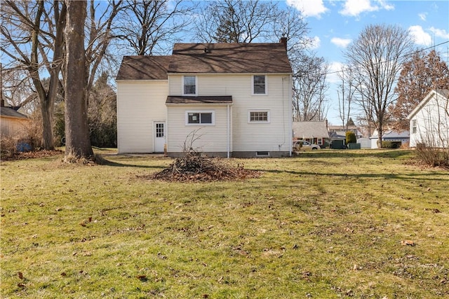 back of property with a lawn and a chimney