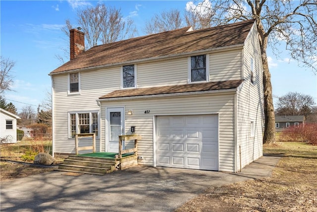 view of front of house with an attached garage and a chimney