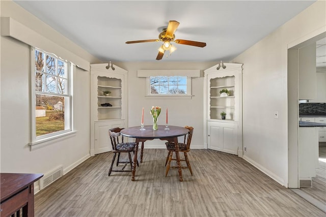 dining room with visible vents, light wood-type flooring, and baseboards