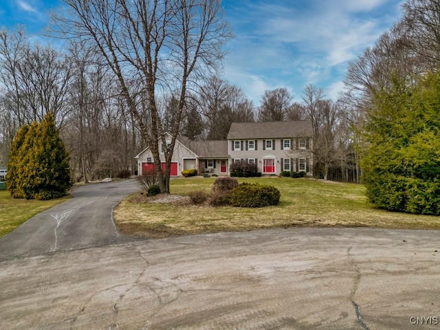 view of front of home with a garage, driveway, and a front lawn