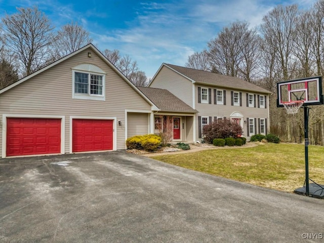 view of front of home featuring a front yard, roof with shingles, and aphalt driveway