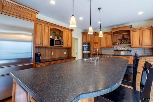 kitchen featuring dark countertops, open shelves, a large island, stainless steel appliances, and a sink