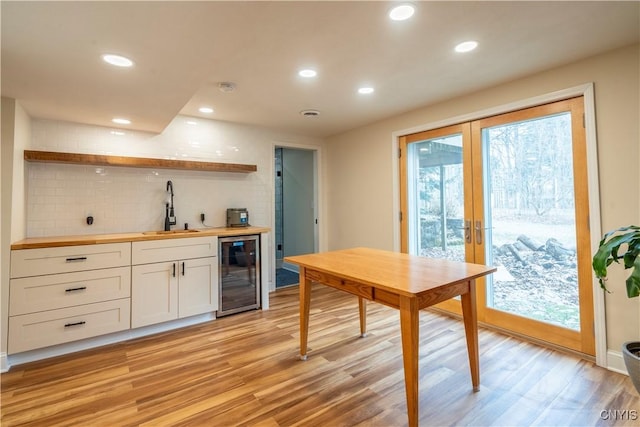 kitchen with a sink, wine cooler, french doors, wood counters, and open shelves