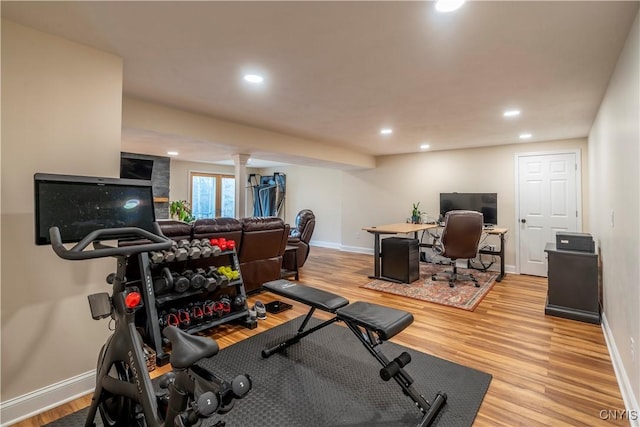 workout room with light wood-style flooring, decorative columns, recessed lighting, and baseboards