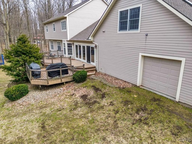 back of house featuring a wooden deck and roof with shingles