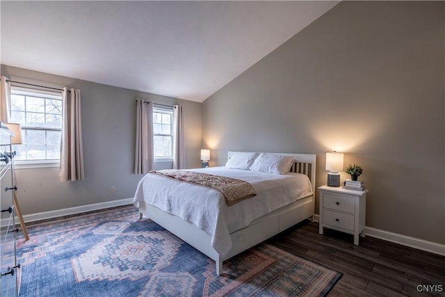 bedroom featuring dark wood-style floors, baseboards, and vaulted ceiling