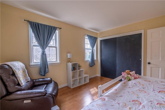 bedroom featuring a closet, baseboards, and wood finished floors