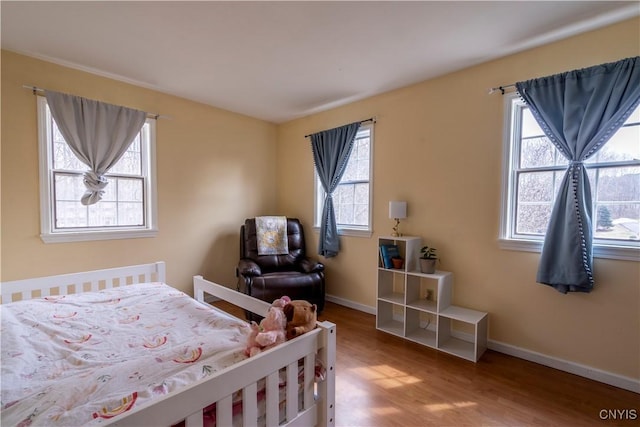 bedroom with baseboards and wood finished floors