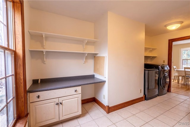 laundry area with light tile patterned floors, baseboards, and washer and clothes dryer