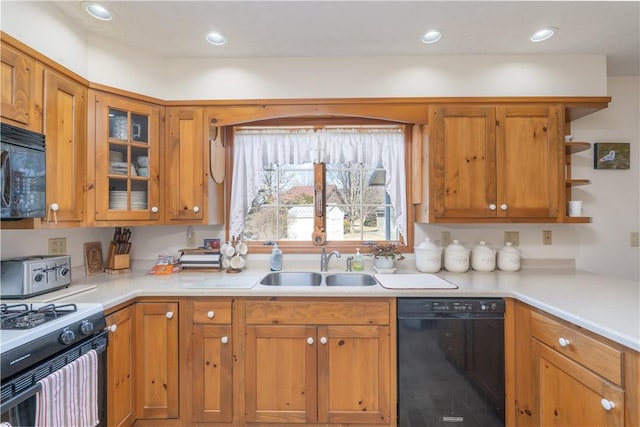 kitchen featuring a sink, brown cabinets, black appliances, and light countertops