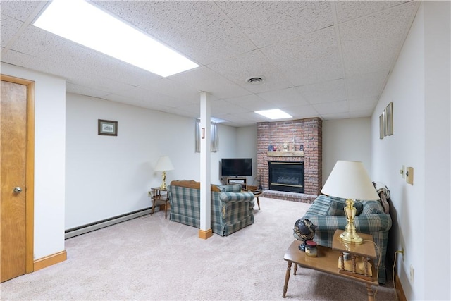 living area with a baseboard heating unit, a fireplace, and carpet flooring