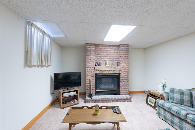 living area with a drop ceiling, baseboards, carpet floors, and a fireplace