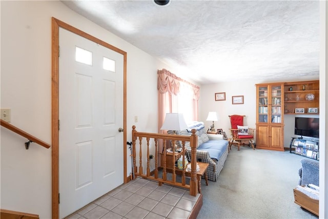 foyer with light carpet and a textured ceiling