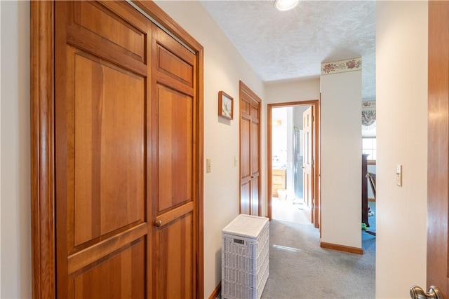 hallway with a textured ceiling and carpet