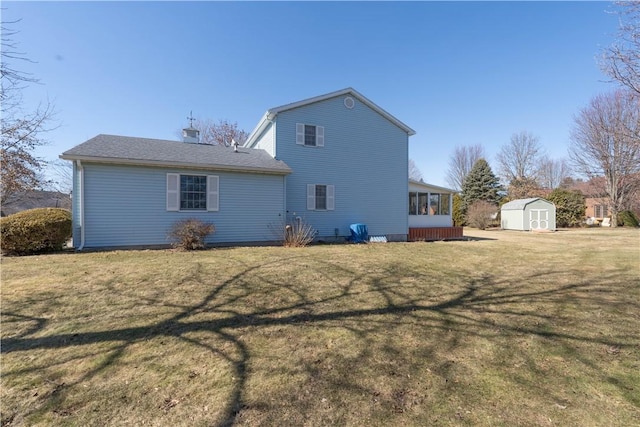 rear view of property with a yard, a storage shed, an outdoor structure, and a sunroom