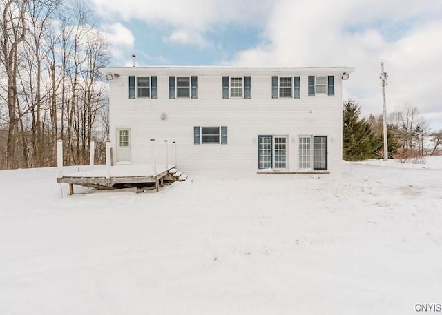 snow covered house featuring a deck