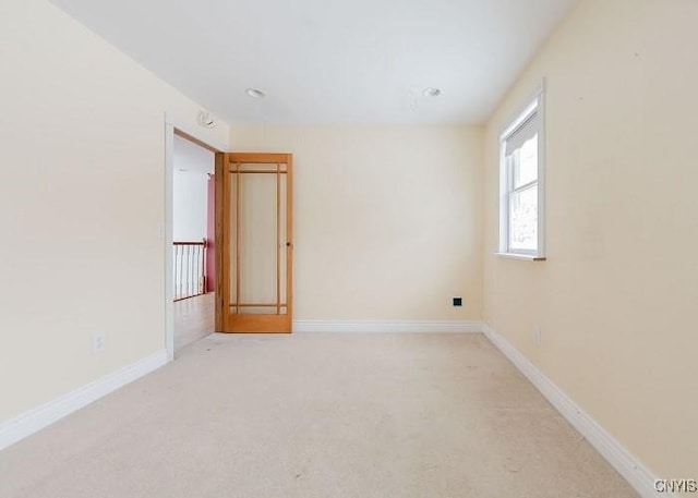 unfurnished room featuring carpet and baseboards