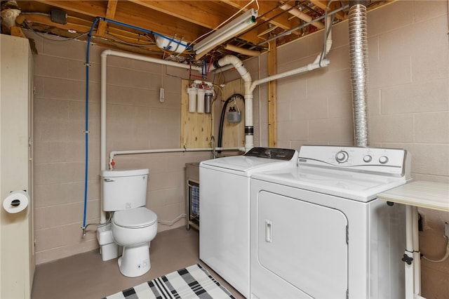 laundry room with laundry area, concrete block wall, and independent washer and dryer