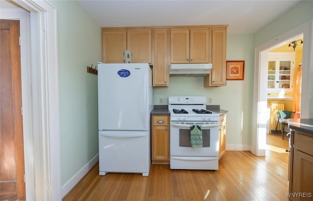 kitchen featuring dark countertops, baseboards, under cabinet range hood, light wood-type flooring, and white appliances