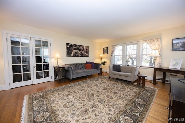 living room featuring wood finished floors, baseboards, and french doors