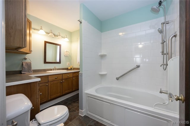 bathroom featuring tile patterned floors, washtub / shower combination, toilet, and vanity