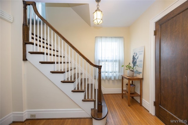 staircase with baseboards and wood finished floors