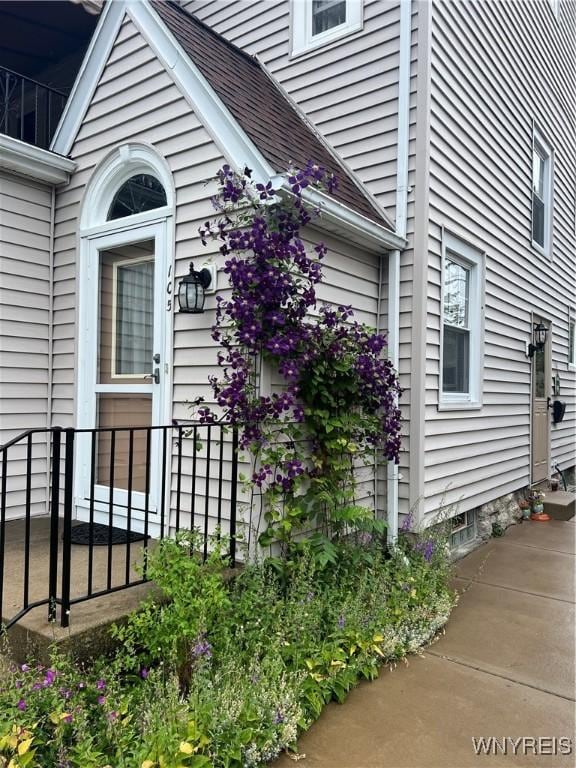 view of side of home with a shingled roof