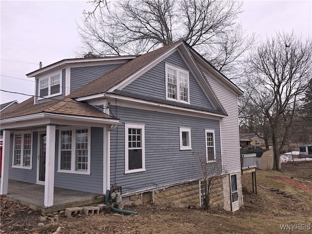 view of side of home with a shingled roof