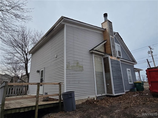 view of side of property featuring a chimney and a deck