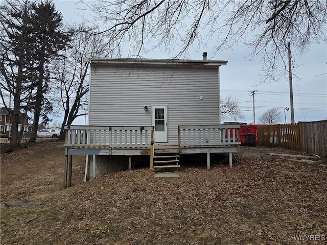 rear view of house featuring a deck and fence