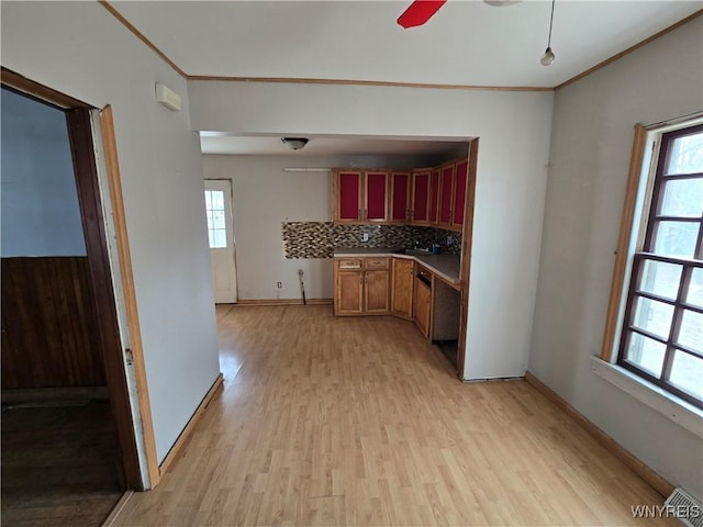 kitchen featuring a ceiling fan, tasteful backsplash, crown molding, light wood finished floors, and baseboards