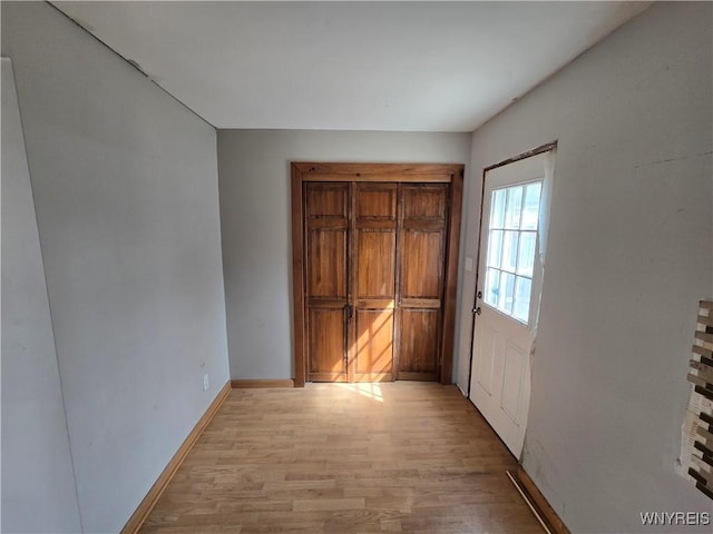 unfurnished bedroom featuring light wood-type flooring and baseboards