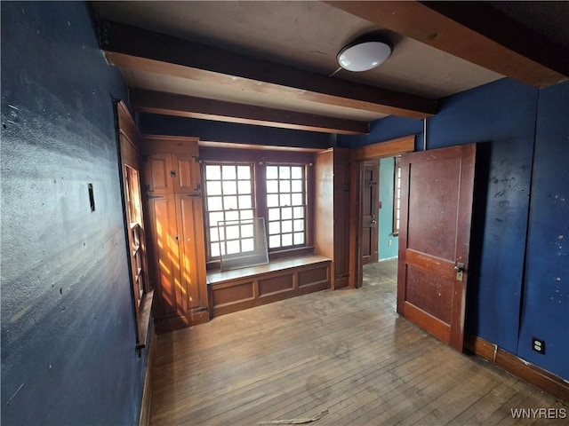 unfurnished room featuring beam ceiling and wood-type flooring