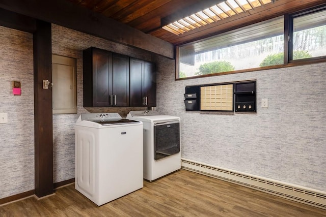 clothes washing area with light wood finished floors, a baseboard radiator, wood ceiling, cabinet space, and separate washer and dryer