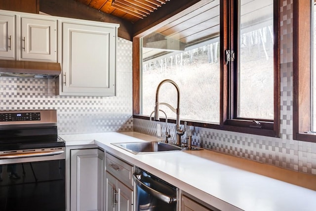 kitchen featuring a sink, light countertops, under cabinet range hood, appliances with stainless steel finishes, and tasteful backsplash