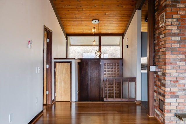 entrance foyer with baseboards, wood ceiling, and wood finished floors