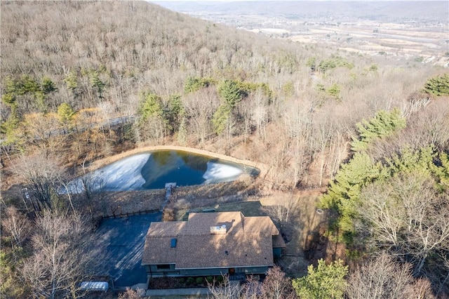 aerial view with a wooded view and a water view