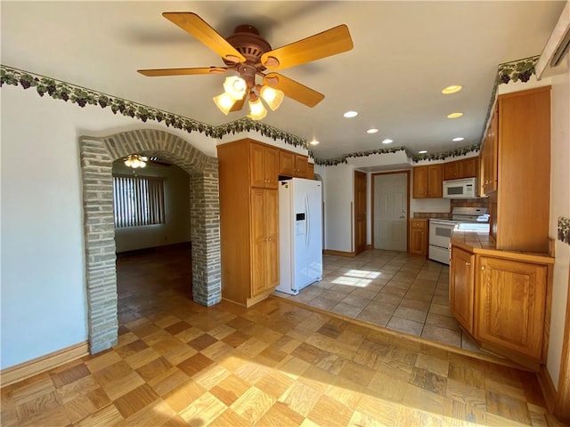 kitchen with white appliances, baseboards, recessed lighting, tile counters, and brown cabinets