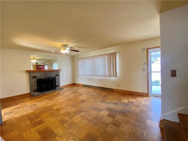 unfurnished living room featuring a stone fireplace, ceiling fan, baseboards, and a baseboard radiator