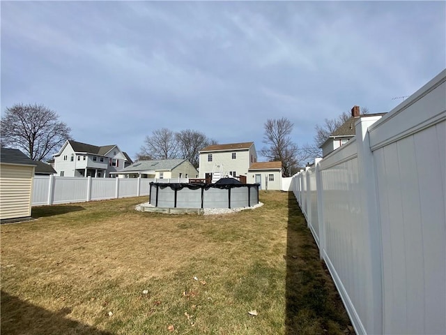 view of yard featuring a fenced in pool, a residential view, and a fenced backyard