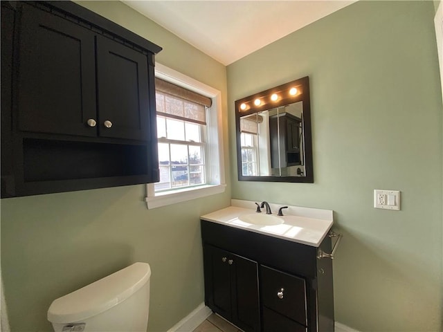 bathroom with vanity, toilet, and baseboards