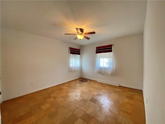 unfurnished room featuring ceiling fan and baseboards