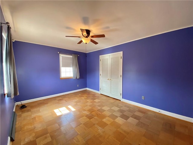 unfurnished bedroom with a closet, baseboards, and a ceiling fan