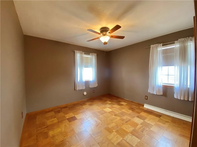 spare room featuring baseboards, baseboard heating, and ceiling fan