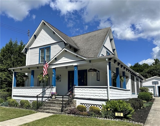 view of front of property featuring covered porch and a shingled roof