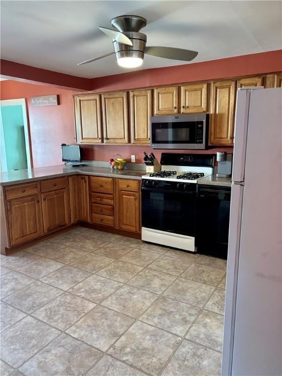 kitchen with stainless steel microwave, ceiling fan, dishwasher, gas range oven, and freestanding refrigerator