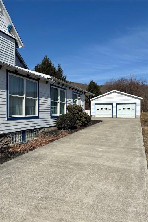 view of side of property featuring a garage and an outbuilding